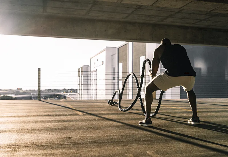 Ein Mann trainiert mit einem Battle Rope