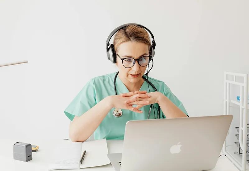 Ärztin spricht per Videocall mit Patient:innen